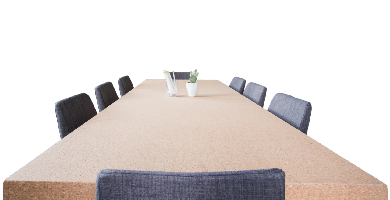 An empty meeting table surrounded by chairs.